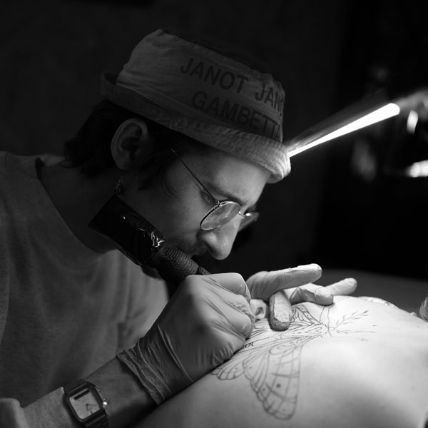 Photo de Coco, tatoueur chez Workers Tattoo Marseille, en train de réaliser un tatouage sur le bras d'un client, concentré et appliqué dans son travail.