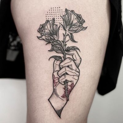 Tatouage de main et rose par Lao – Salon Workers Tattoo Marseille Tatouage représentant une illustration d'une main tenant délicatement une rose, réalisé par Lao chez Workers Tattoo Marseille sur le bras d'un client.